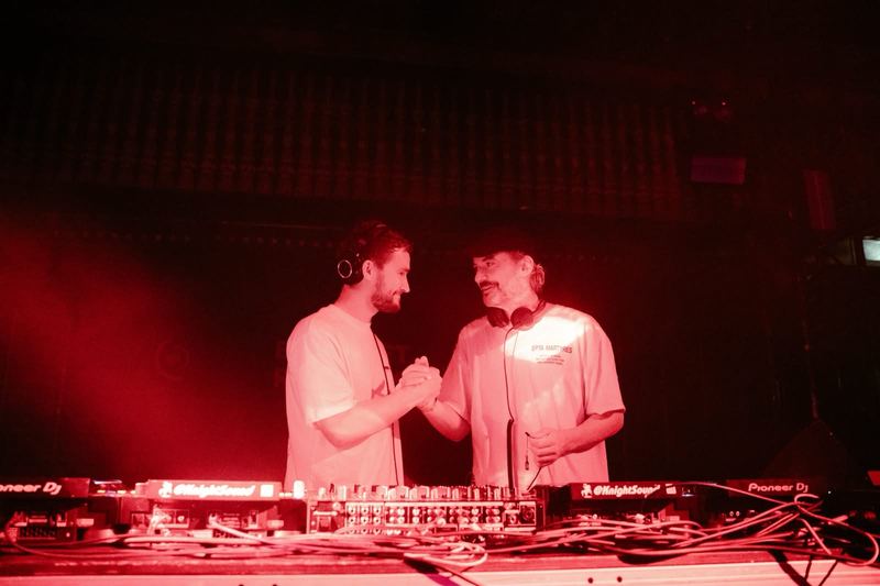 Dindalé and Bonobo shaking hands in the DJ booth