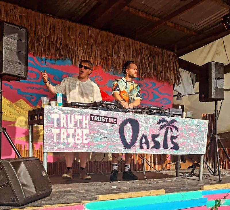 Two DJs behind the decks on the Truth Tribe Oasis stage